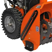 Close-up view of a Husqvarna snow blower attachment with visible auger and tire.