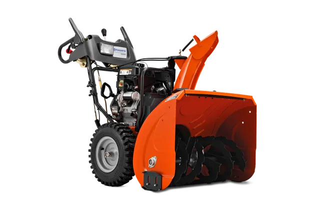 Side view of a Husqvarna snow blower with visible auger and control panel.