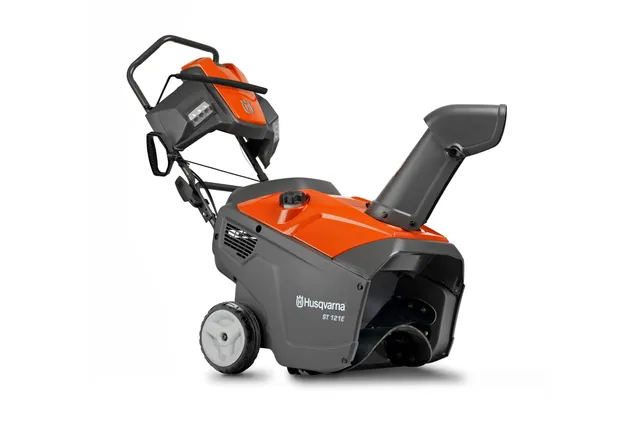 Side view of a Husqvarna snow blower with ergonomic handle and discharge chute.