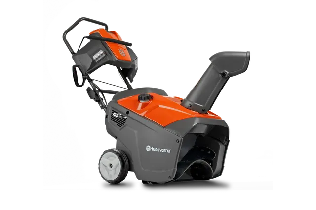 Vue latérale d’une souffleuse à neige Husqvarna avec poignée ergonomique et goulotte de décharge.