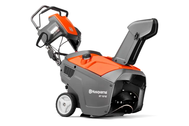 Vista laterale di uno spazzaneve Husqvarna con pannello di comando e scivolo visibili.
