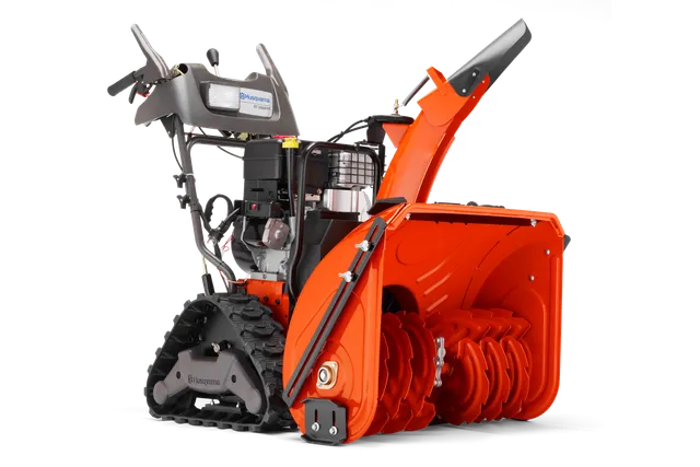 Вигляд збоку снігоочисника Husqvarna з надійним шнеком і системою гусеничного приводу.
