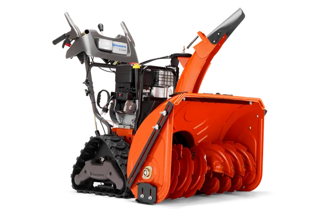Vy från sidan av en snöslunga från Husqvarna med banddrift och snöskruv.