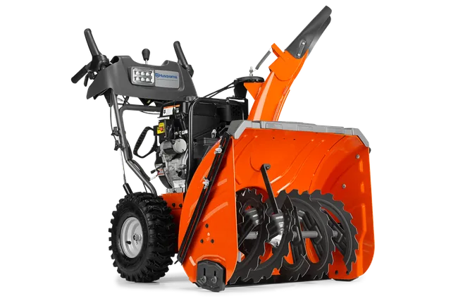 Vue latérale d’une souffleuse à neige Husqvarna avec tarière et panneau de commande visibles.