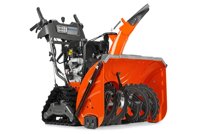 Vue latérale d’une souffleuse à neige Husqvarna avec tarière et panneau de commande visibles.