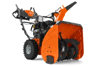 Snøfreser fra Husqvarna sett fra siden med synlig mateskrue og kontrollpanel.