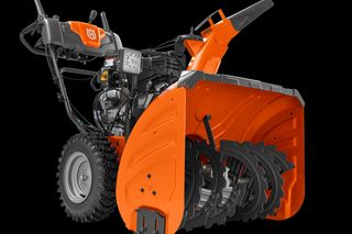 Side view of a Husqvarna snow blower showcasing its auger and controls.