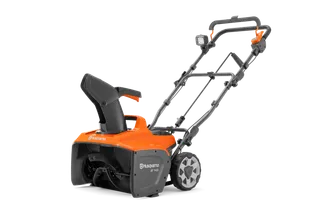 Widok z boku na odśnieżarkę Husqvarna z uchwytem i kołami.