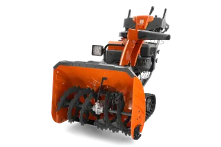 Front view of a Husqvarna snow blower with auger and control panel visible.