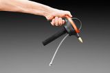 A hand holding a garden spray nozzle with a hose attachment.