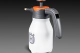 Вигляд спереду пляшки з розпилювачем Husqvarna з ергономічною ручкою та насадкою.