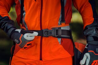 Особа, яка регулює пряжку ременя робочого механізму Husqvarna.