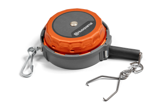 Measuring tape. Top view of a Husqvarna trimmer head with attached metal clips.