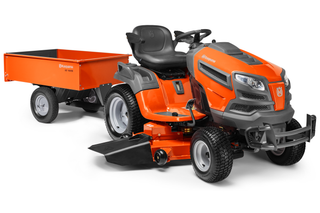 Vue latérale d’une tondeuse autoportée Husqvarna avec une remorque attachée.