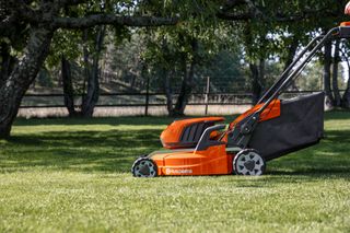 Ein Husqvarna Rasenmäher zum Grasschneiden in einer Gartenumgebung.