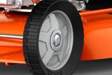Close-up view of a lawn mower wheel and cutting deck.