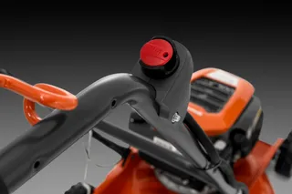 Tagliaerba Husqvarna LB 246E. Vista ravvicinata della maniglia di un tagliaerba con pulsante avvio rosso.