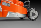 Gros plan sur une roue et une terrasse de tondeuse Husqvarna, montrant l’étiquette du niveau de bruit.