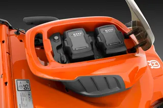 Вид зверху на косарку-трактор Husqvarna з відсіком для подвійного акумулятора.