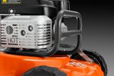 Plan rapproché d’un moteur de tondeuse à gazon avec une calandre et des roues de protection.