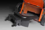 Rear view of a lawn mower with a detached grass chute component.
