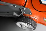 Close-up view of a Husqvarna lawn mower wheel and adjustment lever.