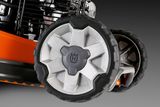 Close-up view of Husqvarna lawn mower wheels with tread pattern.