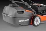 Side view of a Husqvarna lawn mower showing the rear collection bag and wheel design.