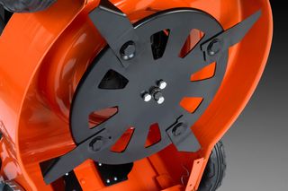 Close-up view of a lawn mower's cutting blades and undercarriage.