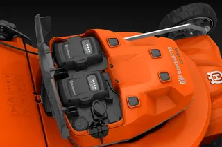 Vy uppifrån av en gräsklippare från Husqvarna med dubbla batterifack.