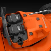 Vy uppifrån av en gräsklippare från Husqvarna med dubbla batterifack.