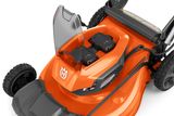 Close-up de um corta-relva Husqvarna que mostra o compartimento das baterias com duas baterias.