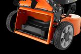 Close-up view of a lawn mower's cutting deck and wheels.