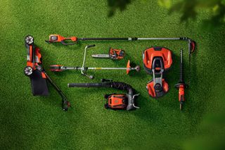 Top view of various gardening tools and equipment arranged on a grass surface.
