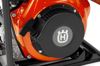 Close-up view of a Husqvarna engine component with a pull start mechanism.