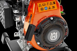 Side view of a Husqvarna engine with visible warning icons and start button.