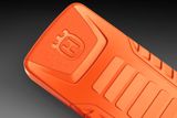 Detailný záber na komponent produktu Husqvarna s reliéfnym logom a textúrovaným povrchom.