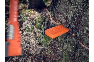Klin stromu vložený do rezaného kmeňa stromu počas lesnej operácie.