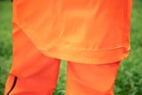 Close-up of a person wearing work trousers in an outdoor setting.