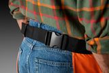 Detailný záber na osobu v pracovnom vybavení so zameraním na nastaviteľnú sponu na opasok.