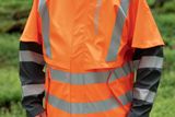 Person wearing high-visibility work gear in a forest setting.