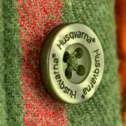 Närbild på en knapp på Husqvarnas arbetskläder.