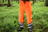 Osoba koja stoji u šumi u Husqvarna zaštitnim hlačama.
