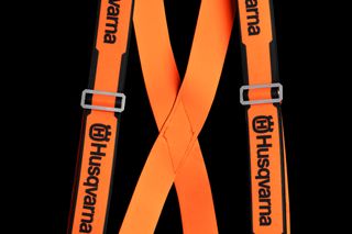 Vorderansicht der Hosenträger der Marke Husqvarna mit verstellbaren Riemen und Clips.