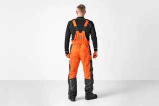 Person facing away wearing Husqvarna chainsaw trousers.