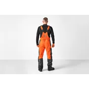 Person facing away wearing Husqvarna chainsaw trousers.