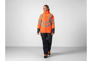 Personen bär arbetskläder med varseljacka och byxor.