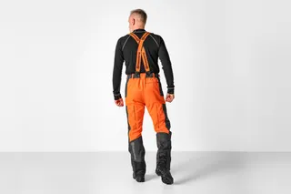 Person facing away wearing work trousers with suspenders.