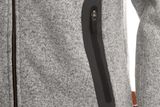 Close-up of a grey jacket with a black zippered pocket and a Swedish flag tag.