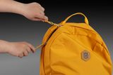 Hände, die am Reißverschluss eines Rucksacks mit einem Husqvarna Logo ziehen.